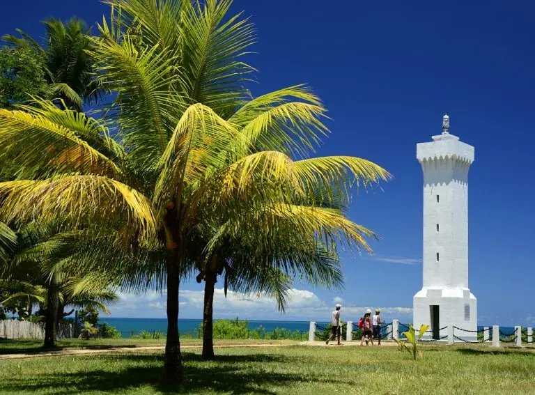Farol histórico de Porto Seguro cercado por coqueiros